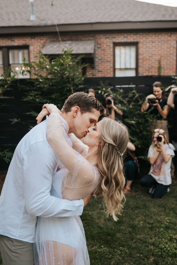 A wedding couple kissing with photographers in the background at a Columbus Georgia Photography workshop hosted by Cirrus Gold Creative Company