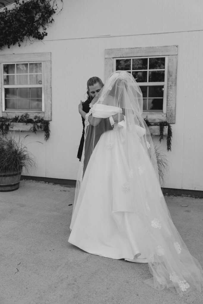 Bride and father of the bride hugging after first look of her in a her wedding gown
