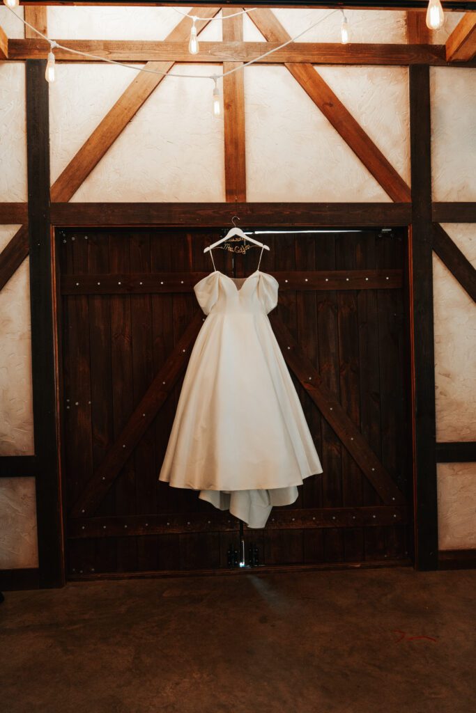 Brides dress hung above barn door